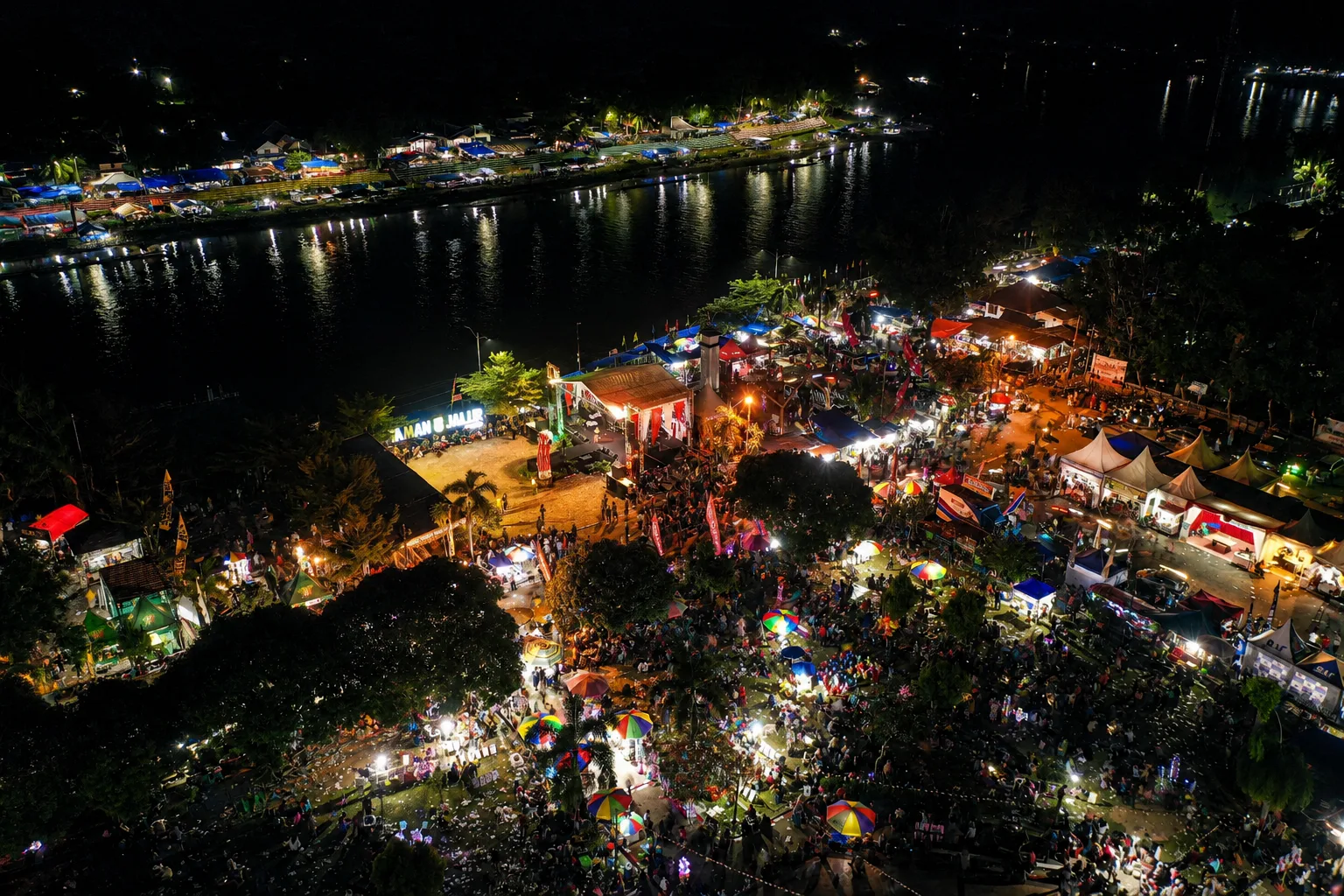 Night-time aerial view of the Pacu Jalur festival area beside the Kuantan River.