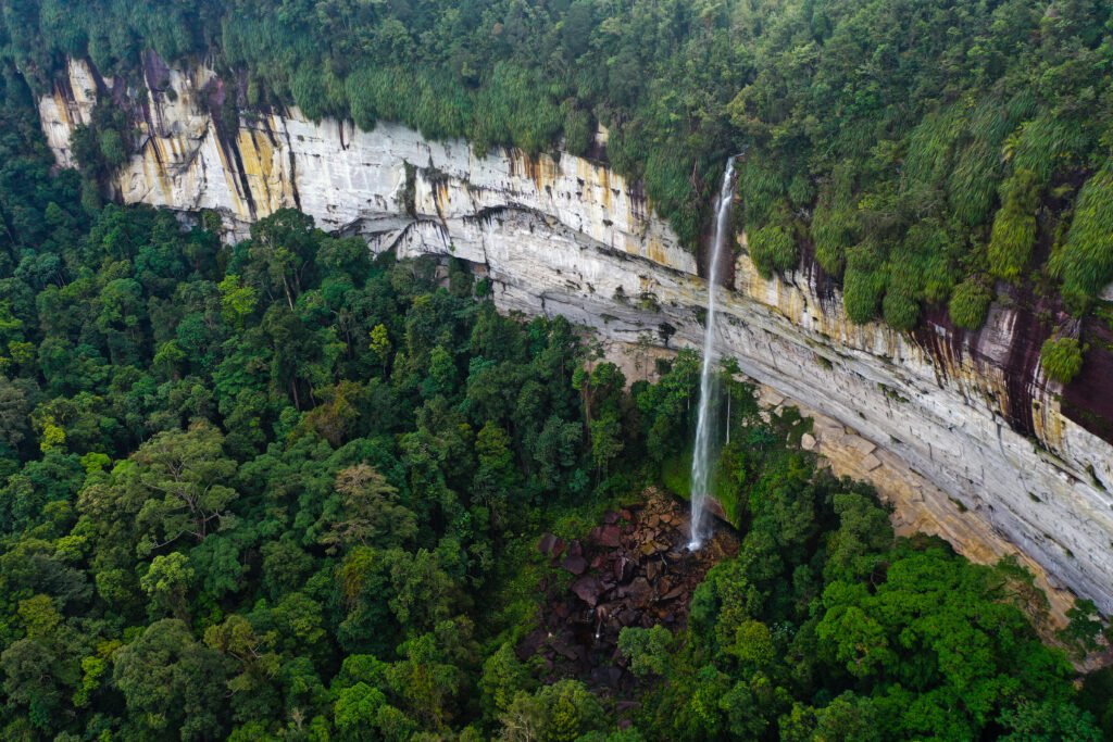 Aerial view of Batang Kapas Waterfall surrounded by tropical forest in Lubuk Bigau, Riau.