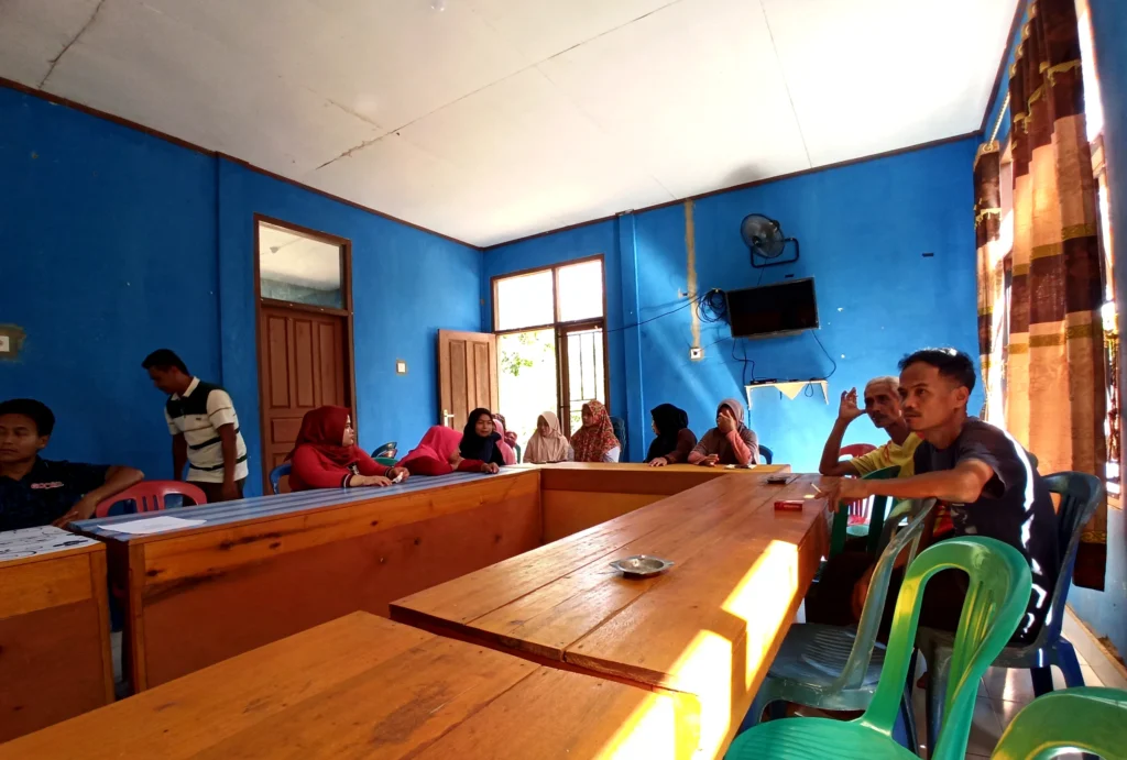 Participants seated around tables during a community water-planning discussion in Lubuk Bigau.